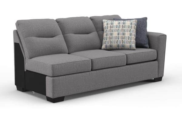 Modern gray fabric sofa with three cushioned seats and backrests, featuring two decorative blue-patterned throw pillows and dark wooden legs.