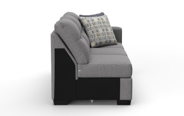Modern gray fabric sofa with tufted back cushions, black base, and patterned throw pillow, showcasing contemporary living room seating.