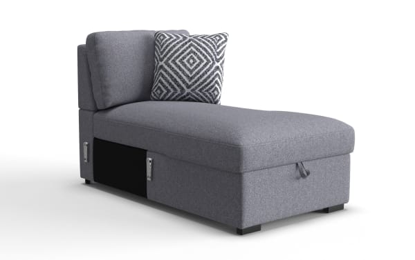Gray upholstered chaise lounge with a geometric patterned throw pillow, featuring storage compartment and fabric pull tab, modern style.