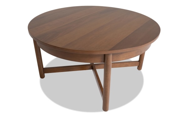 Bettie Walnut Round Coffee Table from Bettie Entertainment & Occasional collection, mid-century modern style, walnut wood finish, compact design with round top and three sturdy legs.