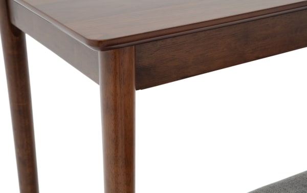 Close-up of a corner of a wooden table with rounded edges and smooth finish, showcasing dark brown wood grain and sturdy cylindrical legs.