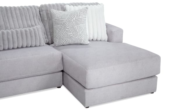 Sofia Gray 159'' 4 Piece Right Arm Facing Chaise Sectional with Ottoman in gray polyester fabric, transitional style with channel tufted back cushions and nine faux fur pillows.