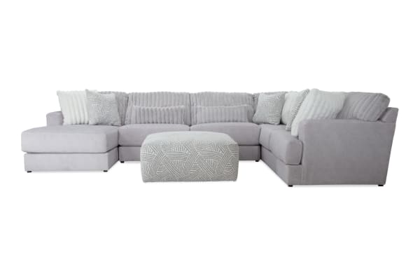Sofia Gray 159'' 4-piece left arm facing chaise sectional with ottoman in gray polyester fabric. Transitional style with channel tufted seat backs, nine faux fur pillows, and patterned memory foam ottoman for enhanced comfort. Part of the Sofia collection.