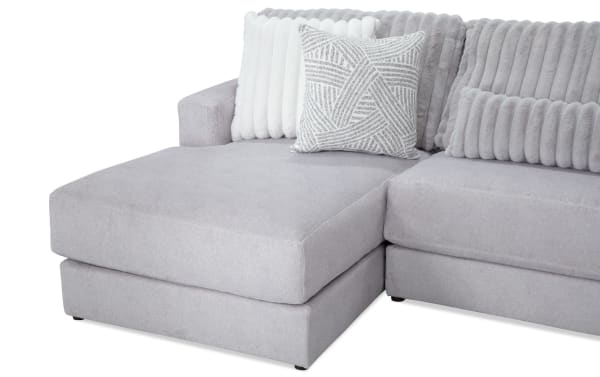 Sofia Gray 159'' 4 Piece Left Arm Facing Chaise Sectional with Ottoman in gray polyester fabric. Transitional style with channel tufted back cushions and nine faux fur pillows for luxury and comfort. Includes patterned ottoman with Bob-O-Pedic Memory Foam for added support.