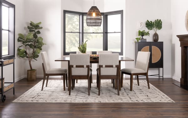 Contemporary Mango 7 Piece Dining Set with solid mango wood 72" table and six beige polyester-upholstered Bob-O-Pedic chairs on patterned rug.