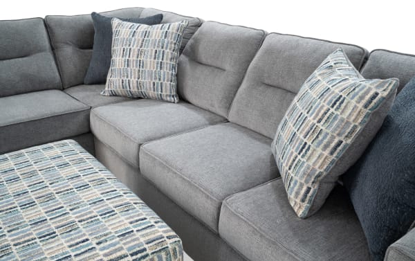 Dylan Slate 112" 2-piece left-arm chaise sectional with ottoman in gray polyester fabric. Transitional style with memory foam cushions and four patterned accent pillows.
