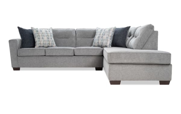Dylan Slate 112" 2-piece right arm facing sleeper chaise sectional in gray polyester fabric, transitional style with tufted back cushions and four accent pillows, featuring a queen cooling Bob-O-Pedic gel memory foam mattress for comfort and temperature regulation.