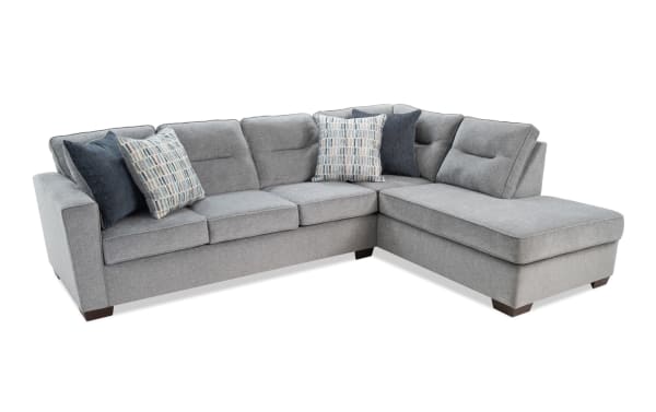 Dylan Slate 112" transitional 2-piece right arm facing sleeper chaise sectional in gray polyester fabric with four accent pillows and queen cooling gel memory foam mattress.
