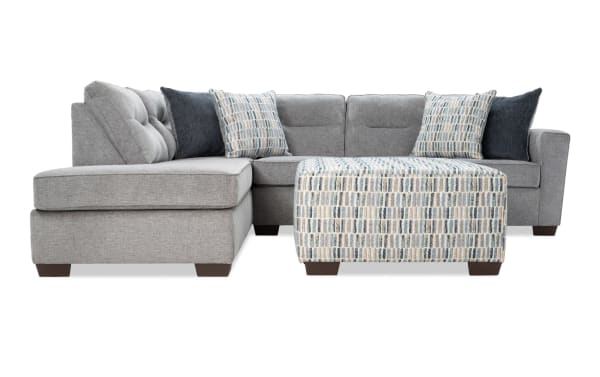 Dylan Slate 112" 2-piece left arm facing sleeper chaise sectional in gray polyester fabric with four accent pillows and patterned ottoman.