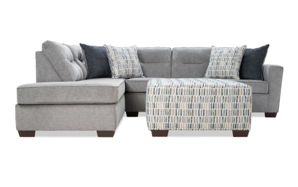 Dylan Slate 112'' 2-piece left arm facing sleeper chaise sectional in gray polyester fabric with transitional style. Includes four accent pillows, patterned ottoman, and queen cooling Bob-O-Pedic gel memory foam mattress.