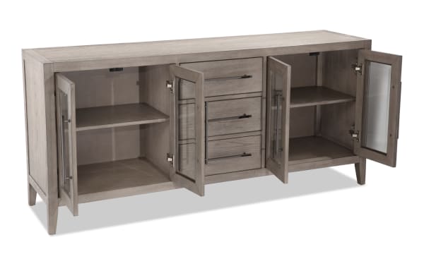 Villa 70" Gray Transitional TV Stand with MDF and glass construction, featuring three center drawers, two glass-paneled cabinets with shelves, and cord management. Designed for TVs up to 70 inches.