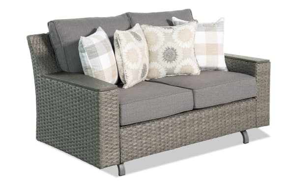 Cottage Chic Gray Wicker Outdoor Gliding Loveseat with weather-resistant gray polyester cushions, all-weather wicker, and powder-coated metal frame in transitional style.
