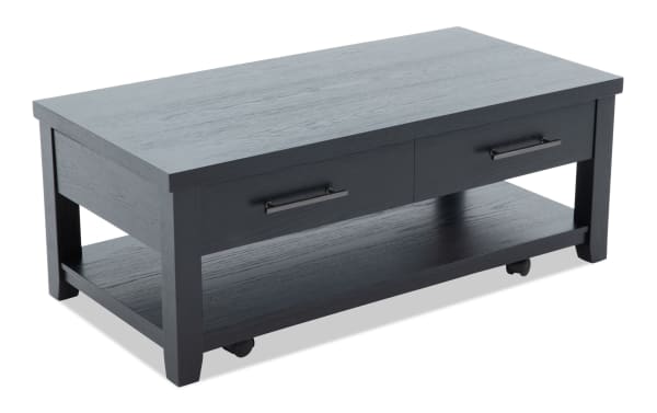 Rectangular black wooden coffee table with two drawers, metal handles, and a lower shelf on caster wheels, modern design.