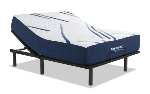 Queen plush mattress from Bob-O-Pedic Signature Gel collection on a wooden bed frame with adjustable Power Bob Essential Base, featuring a navy blue gel memory foam layer, white quilted cover, and dual comfort options. Room includes modern nightstands with lamps, a gray rocking chair, striped area rug, and decorative plants.