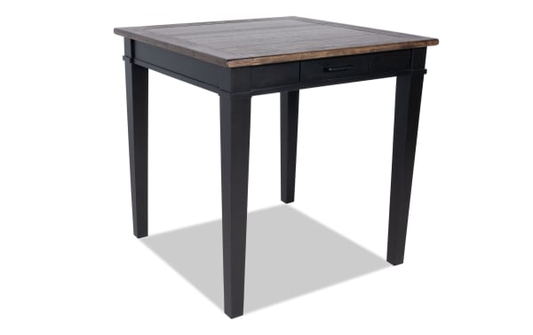 Montana Black & Brown Square Counter Height Storage Dining Table with rustic MDF top, distressed oak veneer, antique black base, and storage drawer.
