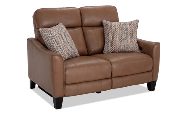 Empire Cognac Leather 59'' Power Reclining Loveseat with power headrest, brown transitional style, leather upholstery, and patterned accent pillows.