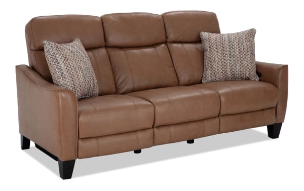 Empire Cognac Leather 82'' Power Reclining Sofa with Power Headrest in brown leather, transitional style, featuring plush cushions, accent pillows, and dark wooden legs.