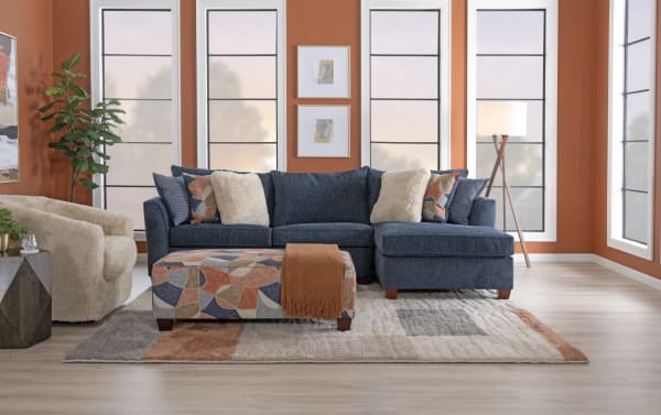 Brynn Navy 114'' 3 Piece Sectional with soft navy polyester fabric, Bob-O-Pedic memory foam cushions, and colorful geometric ottoman.