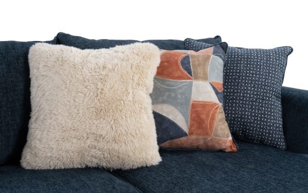 Brynn Navy 114'' 3 Piece Sectional with navy blue polyester fabric upholstery, transitional style, and three plush accent pillows including faux fur, abstract pattern, and textured navy designs.