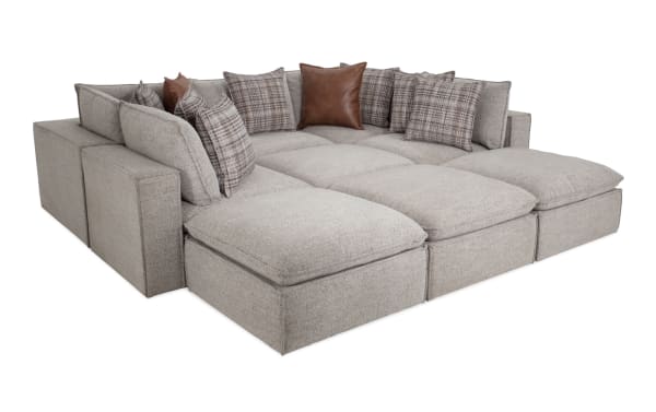 Transitional Infinity Gray 147'' 9-piece modular sectional with 4 ottomans, 3 armless chairs, 2 corners in gray polyester fabric and feather blend pillows.