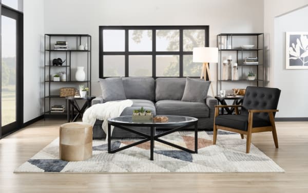 Transitional Aspen Charcoal 86'' Sofa in gray polyester fabric with plush cushions, accent pillows, and durable plywood frame in a modern living room setting.