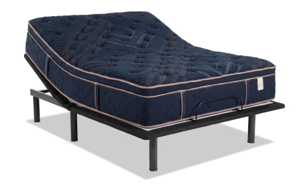 Queen plush Power Bob Essential Base bed set with Copper Radiance 14.5'' mattress in navy blue quilted cover, beige upholstered frame, black metal nightstands, and wooden desk in modern bedroom.