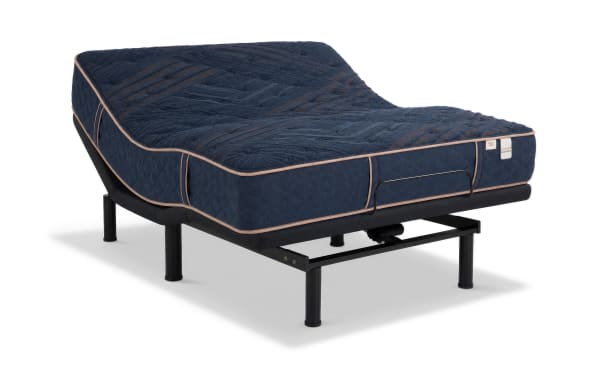Queen-sized Power Bob Ultra Base with Copper Radiance 13'' Extra Firm Mattress in navy blue quilted cover, beige upholstered bed frame, and modern bedroom setup.