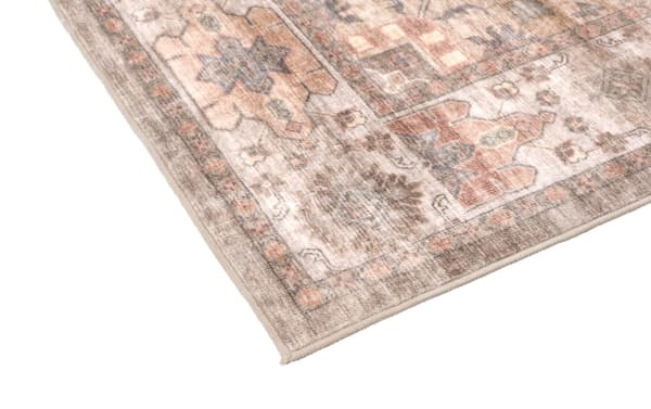 Corner of a Monarch 5' x 7' washable rug in red with a vintage-inspired oriental pattern, low pile, and durable polyester fabric.