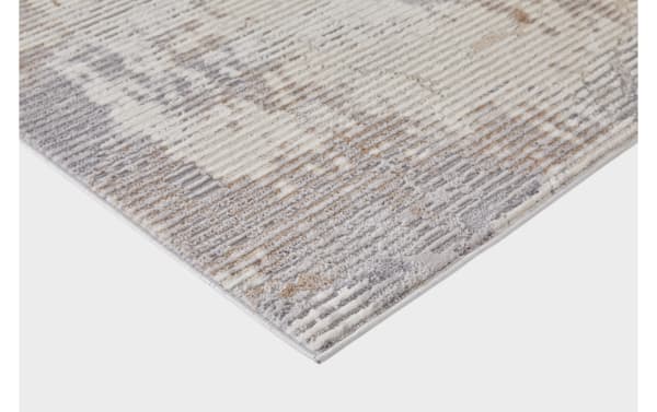 Corner close-up of Otto 8' x 10' cream and light gray abstract rug with thin polyester shag and muted multicolored pattern