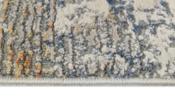 Close-up of Aurora 5' x 7' Cream & Light Gray Abstract Rug edge showing low pile polyester fabric with beige, ivory, and multicolored abstract pattern.