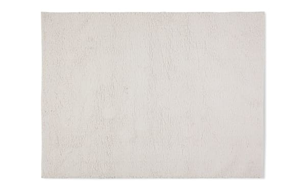 Ivory Ava 8' x 10' shag rug with plush polyester fabric, featuring a soft, shaggy texture and neutral beige color for versatile room decor.