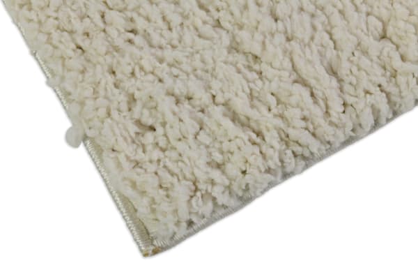 Ivory Ava 8' x 10' shag rug with plush polyester fabric, featuring a soft, dense pile and neutral beige color for versatile room decor.