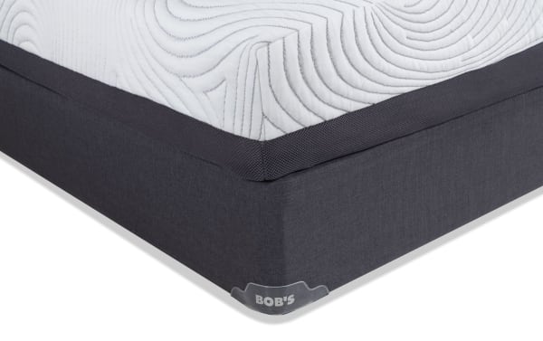 Corner view of the Prize Hybrid 10'' Full Firm Standard Mattress Set from Bob's, featuring white quilted top with gray mesh sides and dark gray foundation.