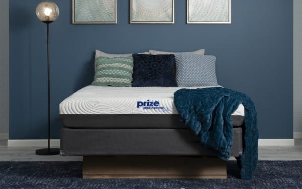 Prize Gel 10'' Twin XL Firm Standard Mattress Set by Bob-O-Pedic with white gel memory foam top, charcoal foundation, and blue textured throw blanket.
