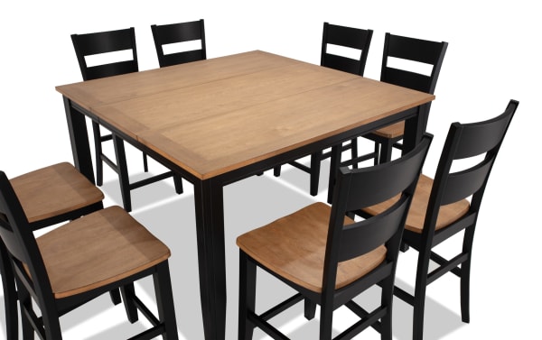 Blake 9 Piece Black & Natural Extendable Counter Height Dining Set with eight black ladder-back stools and a natural wood top table with an 18" leaf. Crafted from MDF, hardwood, and rubberwood solids in a cottage style, this durable farmhouse set extends from 36" to 54" for large family or entertaining needs.