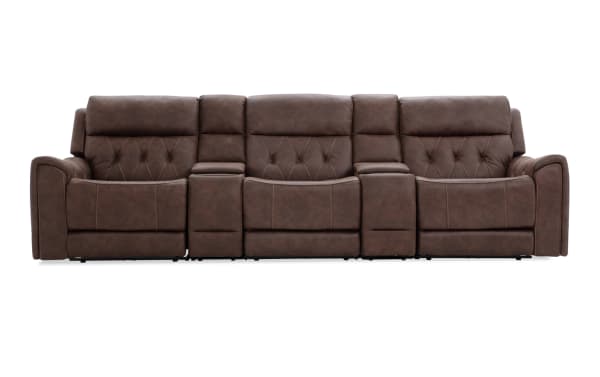 Brown leather reclining three-seat sofa with diamond tufted backrests, padded armrests, and built-in center console for living room seating.