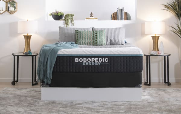 Energy 14'' Queen Plush Standard Mattress Set by Bob-O-Pedic, black quilted gel-grid memory foam with charcoal, plush comfort, includes foundation, styled with gray bedding and teal throw.