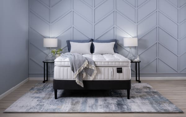 Obsession 16.5'' Queen Ultra Plush mattress set in white with gray base, featuring plush quilted top, graphite memory foam, coil system, and matching pillows.