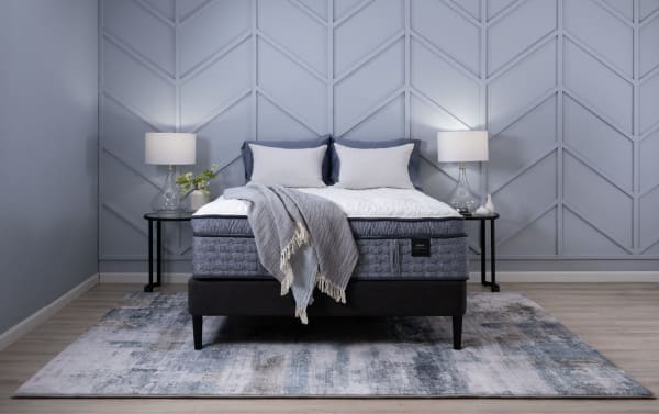 Power Bob Ultra Base with Envy 16'' Twin XL Ultra Plush Mattress in gray with hand-tufted Tencel knit cover, plush hybrid layers, black adjustable base, side tables, and lamps.