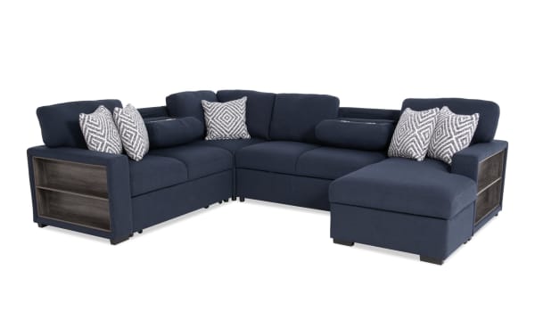 Transitional Playday Navy 119" 4-piece right arm facing pop-up sleeper chaise sectional in blue polyester fabric, featuring built-in bookshelf, memory foam cushions, storage chaise, USB & USB-C ports, accent pillows, and drop-down table with cupholders.
