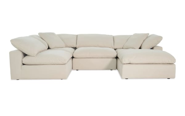 Dream Shell 131'' beige 5-piece modular sectional with two armless chairs, two corners, and one ottoman. Transitional style in soft polyester and nylon fabric with oversized reversible cushions and feather blend toppers for customizable, comfortable living room seating.