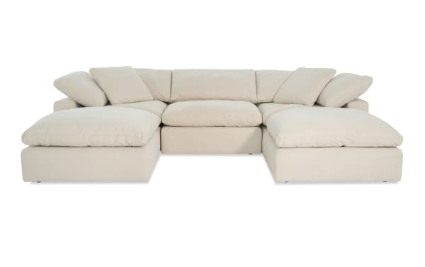 Dream Shell 131'' beige 5-piece modular sectional with 2 corners, 2 ottomans, 1 armless chair in transitional style. Fabric upholstery with reversible, oversized cushions.