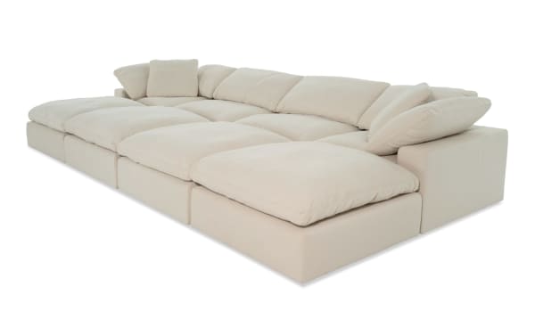 Dream Shell 174" 8-piece beige modular sectional with 4 ottomans, 2 armless chairs, and 2 corners in transitional style. Upholstered in soft polyester-nylon fabric with oversized reversible cushions and feather blend toppers for customizable, cozy living room seating.