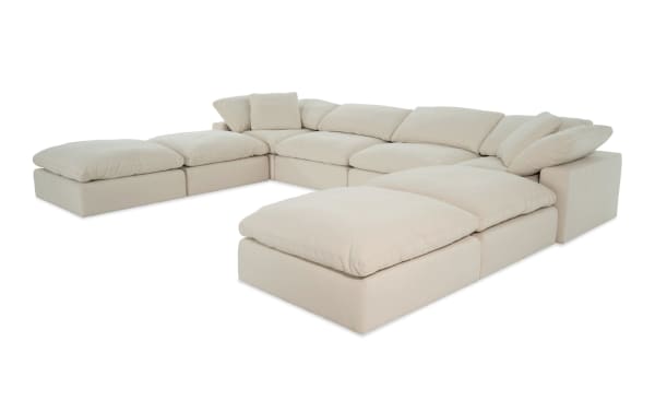 Dream Shell 174'' beige 8-piece modular sectional with 4 ottomans, 2 armless chairs, and 2 corners in transitional style. Polyester fabric upholstery with oversized reversible cushions and feather blend toppers for customizable living room seating.