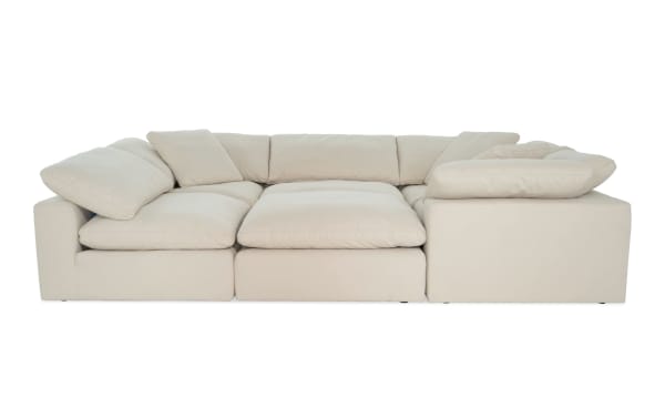 Dream Shell 131'' beige 6-piece modular sectional with 3 corner seats, 2 armless chairs, and 1 ottoman. Transitional style, polyester fabric upholstery with reversible, oversized cushions and feather blend toppers.