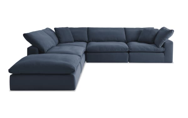 Dream Navy 131'' 5 Piece Modular Sectional in navy blue fabric with 2 armless chairs, 2 corners, 1 ottoman, and accent pillows. Transitional style, polyester-nylon upholstery, oversized reversible cushions with feather blend topper from the Dream collection.