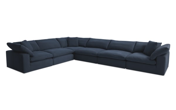 Dream Navy 174'' 6 Piece Modular Sectional in navy blue fabric with polyester and nylon upholstery. Transitional style with oversized reversible cushions and three accent pillows. Modular design includes 3 armless chairs and 3 corner units for customizable living room seating.