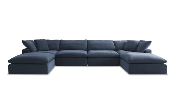 Dream Navy 174'' 6-piece modular sectional in navy blue fabric, transitional style with reversible oversized cushions, includes 2 armless chairs, 2 corners, and 2 ottomans for customizable living room seating.