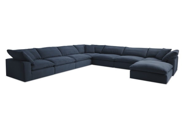 Dream Navy 174'' 8 Piece Modular Sectional in navy blue fabric, featuring 4 armless chairs, 3 corner seats, 1 ottoman, and 3 accent pillows. Transitional style with polyester and nylon upholstery, reversible oversized cushions with feather blend toppers for customizable living room seating.