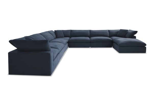 Dream Navy 174'' 8 Piece Modular Sectional in navy blue fabric with 4 armless chairs, 3 corners, 1 ottoman. Transitional style with reversible, oversized cushions in polyester and nylon blend. Part of the Dream collection, customizable modular seating for living rooms.